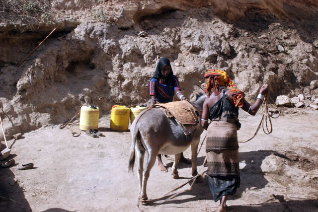 People are going for water, which is retrieving by men-chain from 20m deep wellp. Singing well in Dublock. South,  Ethiopia.
